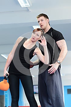 Personal trainer with female client using weights