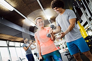 Personal trainer giving instructions a woman in gym