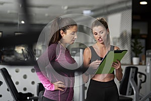 Personal trainer guiding young woman photo