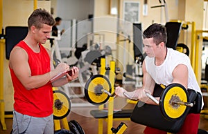 Personal trainer helping client in gym