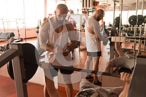 Personal Trainer Helping Man On Chest Exercise