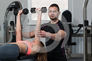 Personal Trainer Helping Woman On Chest Exercise