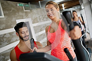 Personal trainer helping a woman to working out in gym. Sport people healthy lifestyle concept