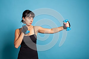 Personal trainer holding dumbbells stretching arm muscles