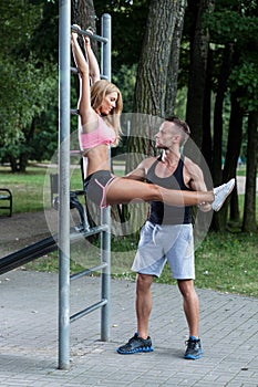 Personal trainer insuring woman during exercise