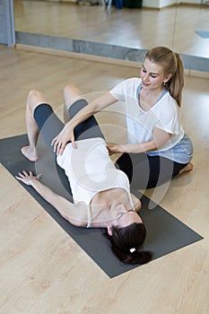 Personal trainer, pilates. Physical therapist helping caucasian woman in her workout at fitness studio, selected focus