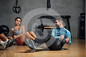 Personal trainer showing how to do twists abs exercise with kettlebell in gym