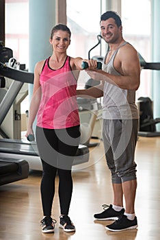 Gym Coach Helping Woman On Shoulder Exercise