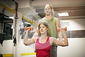 Personal trainer training his client in the gym.