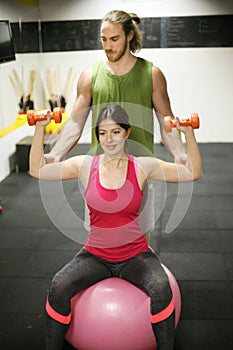 Personal trainer training his client in the gym.