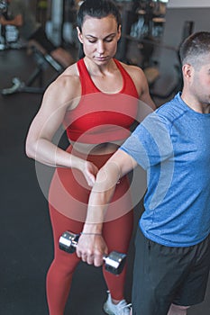 Personal trainer woman holding clients elbow during workout concept
