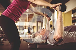 Personal trainer working exercise with senior man.