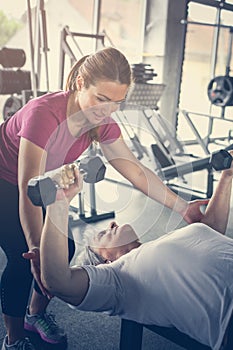 Personal trainer working exercise with senior woman.