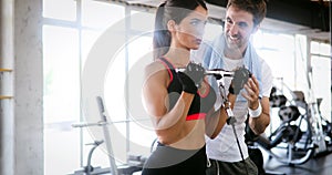 Personal trainer working with his client in gym