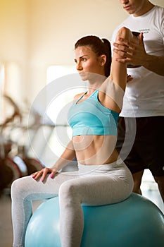 Personal trainer working with his client in gym