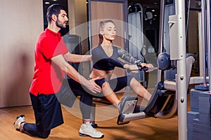 Personal trainer working with his client in gym