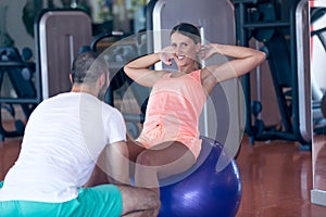 Personal trainer working with his client in gym