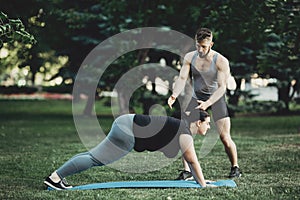 Personal trainer working with his client outdoors