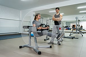 Personal trainer working with young and beautiful woman