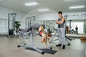 Personal trainer working with young and beautiful woman