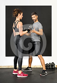 Personal training assisting a woman with weights