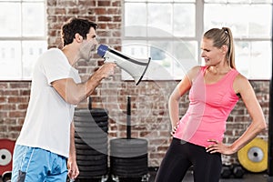 Personal trainor motivating his client with megaphone