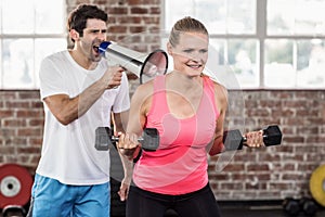 Personal trainor motivating his client with megaphone