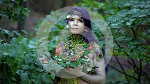 Personification of nature looking camera standing among forest trees, ecology