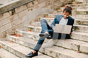 Personnel consultant chatting with client by laptop on steps.