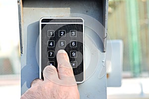 a persons hand pressing a password on a numerical keypad to lock or unlock an alarm system, opening garage gate for car entry,