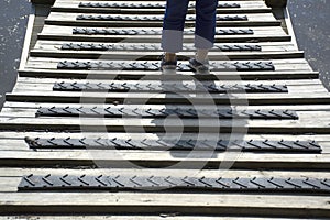 Persons legs staying on bridge with rubbery non slippery protection.