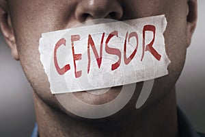 A persons mouth is sealed with masking tape. The concept of censorship in society