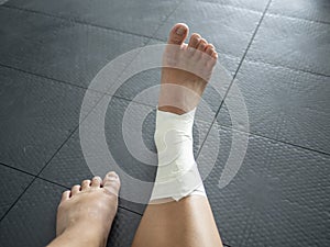 Perspective of an athlete looking at her taped ankle sprain