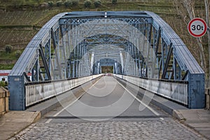 Perspective center angle view at the bridge in metallic truss structure over Douro River in Pinhao city, asphalt road photo