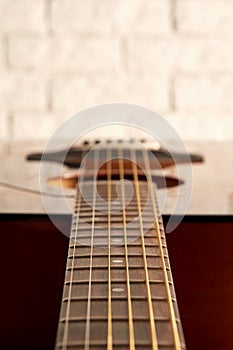 Perspective close up view of an acoustic guitar neck and strings