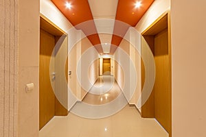 Perspective corridor of condominium. Modern and bright interior in the hotel. Long hallway with doors