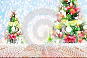 Perspective empty wooden table with blur christmas tree and snow flake background. For product display montage or design layout