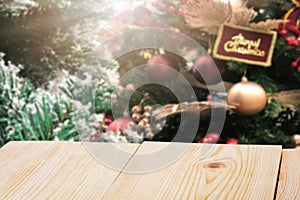 Perspective empty wooden table and christmas tree blur decoration background, for product display montage or design layout