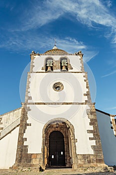 Perspective of the bell tower facade with its arches of the Mother Church of PedrogÃÂ£o Grande PORTUGAL photo