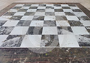Perspective image of floor with black and white tiles. Chess board made of stone. Old picture