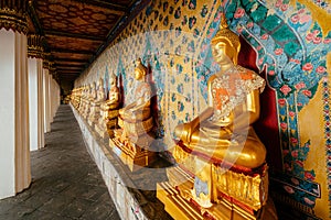 Golden Buddha statues seated in a perspective line at Wat Arun