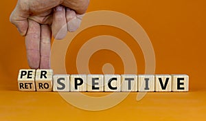 Perspective or retrospective symbol. Businessman hand turns cubes and changes word `retrospective` to `perspective`. Beautiful