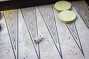 Perspective shoot of dices on backgammon under open light with play stones