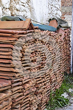 Perspective shot of ornage colored roof tile near masonry wall photo