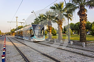 Perspective shot of tramway in action with pedestrian stones at sunset time in Izmir at Turkey