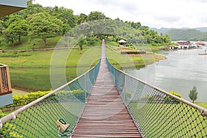 Perspective view of adventure wooden rope suspension bridge crossing river