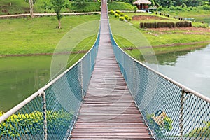 Perspective view of adventure wooden rope suspension bridge crossing river
