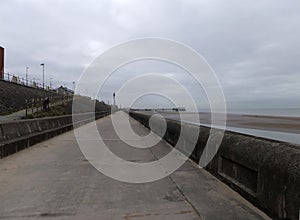 Perspective view along the pedestrian promenade in blackpool with a view of the town south pier and tower in the distance