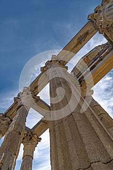 Perspective view from below of the marble columns with Greek capitals of the Roman temple of Diana with doves perched on the