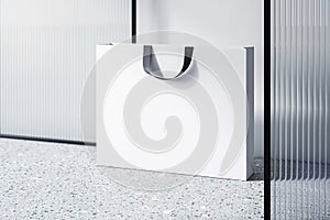 Perspective view on blank white paper shopping bag with place for your brand name or text on light concrete floor and light wall